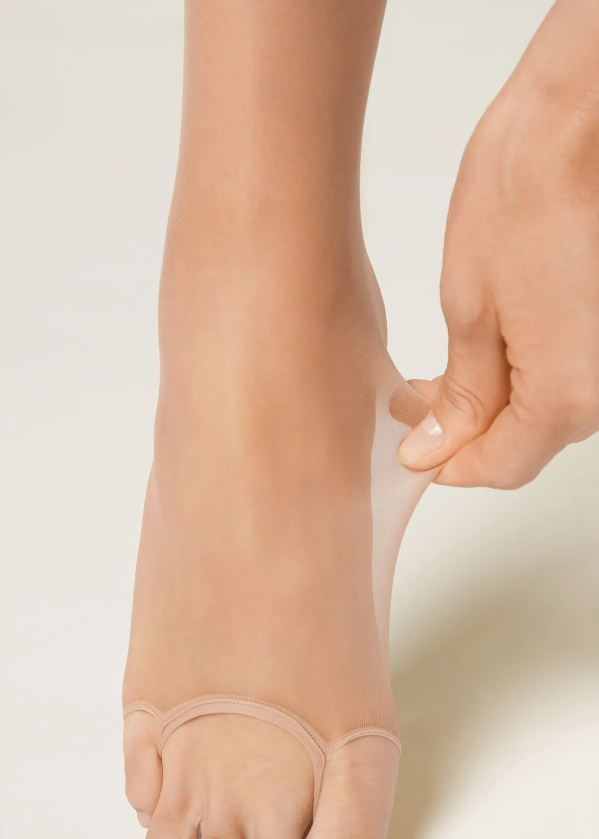 Calzedonia Open Toe Sheer Tights: a hand lifts the tights at the instep to show the band that runs across the toes, leaving them bare