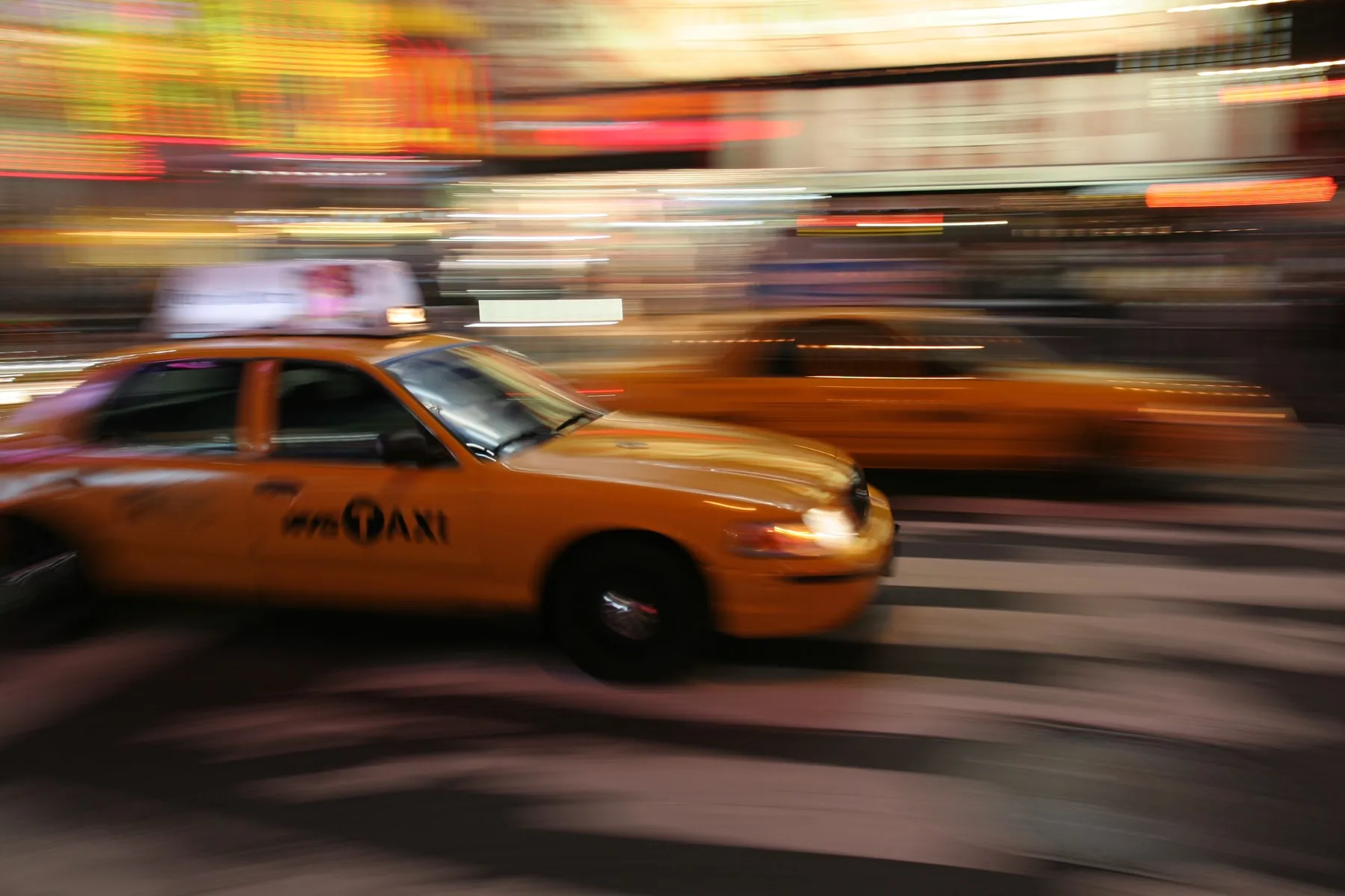 Un taxi giallo passa veloce a Times Square, Manhattan