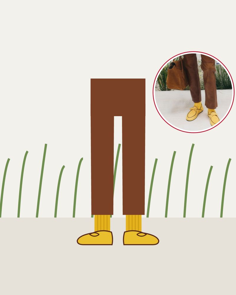 Illustration: yellow ribbed socks in yellow loafers under brown leather trousers, on a white platform among dune grasses, with a photo of the look