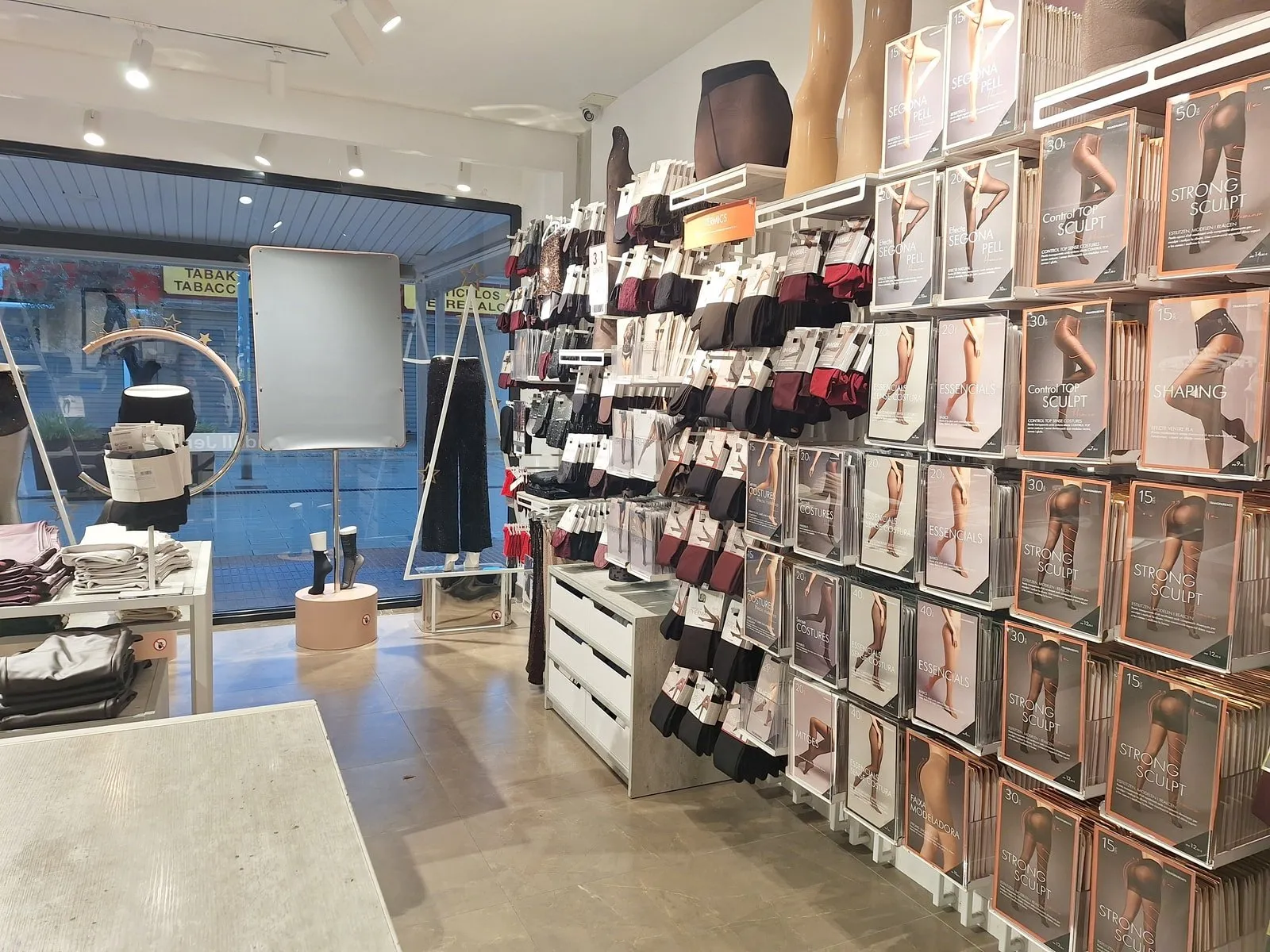 Interno di un negozio Calzedonia con una parete di confezioni di collant e calze