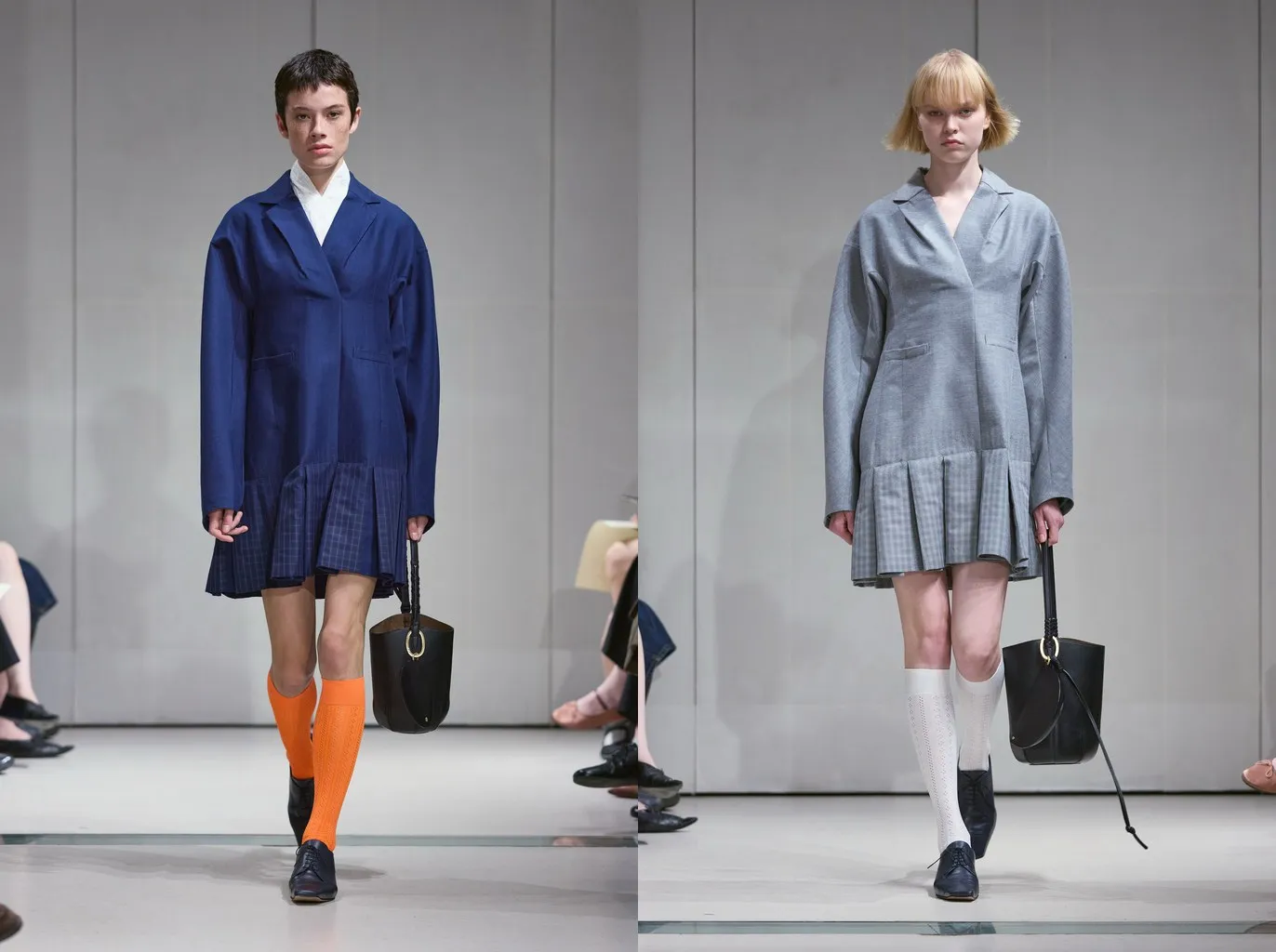 Looks 26 and 29 from the Mame Kurogouchi spring/summer 2027 show: ribbed orange and white openwork knee-highs with navy brogues, under pleated navy and grey jacket dresses